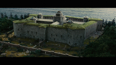 an old building with a green roof next to a body of water