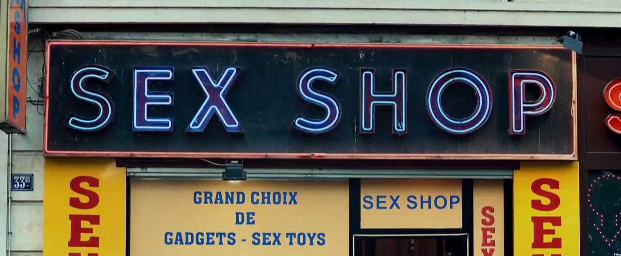 a store front with a neon sign that says sex shop