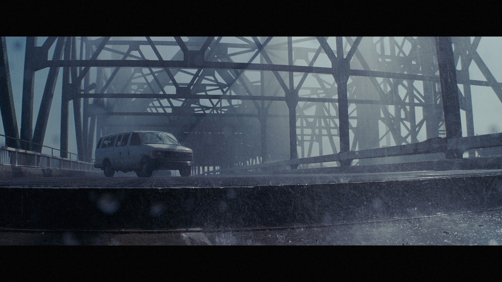 a car driving on a bridge in the rain