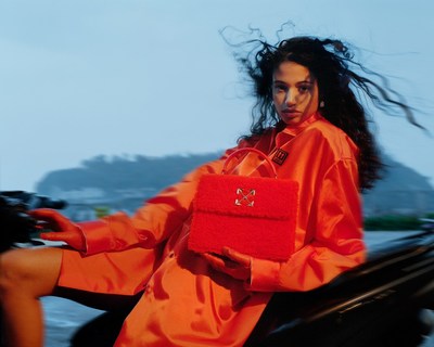 a woman in an orange outfit sitting on a motorcycle