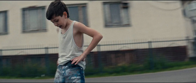 a young boy riding a skateboard down a street