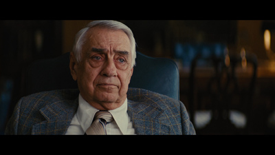 a man in a suit and tie sitting in a chair