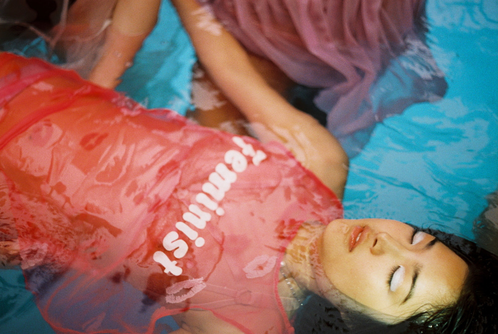 a woman in a red shirt floating in a pool of water