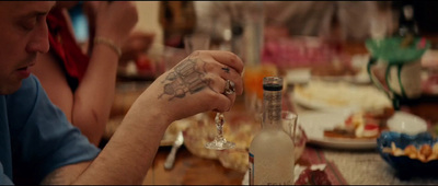 a man sitting at a table holding a wine glass