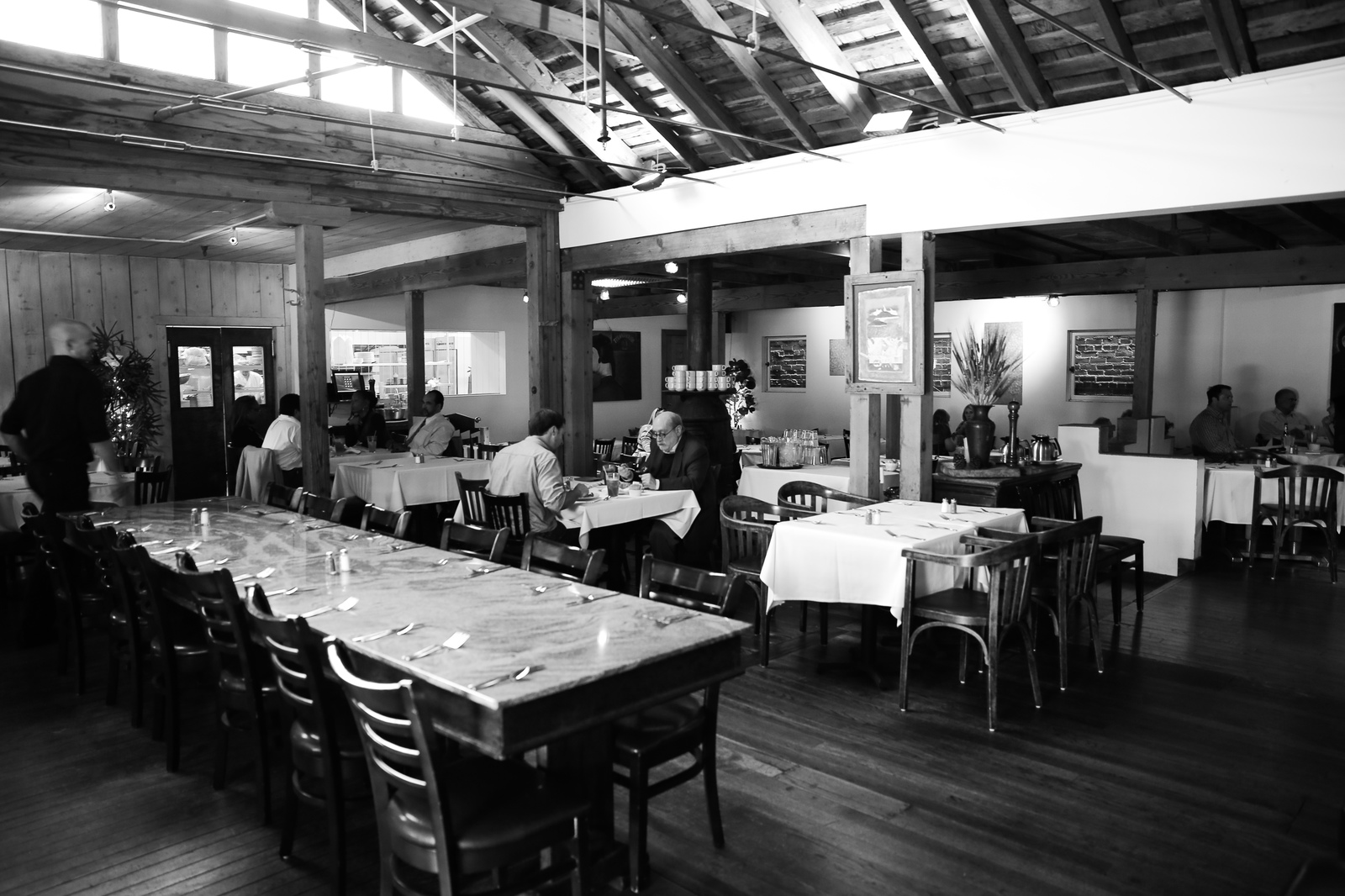 a black and white photo of people eating in a restaurant