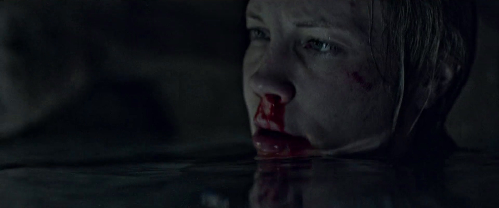 a woman with blood on her face in water