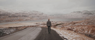 a person standing on a road in the middle of nowhere