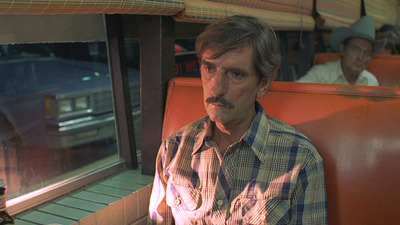 a man with a mustache sitting on a train