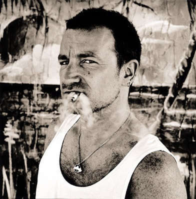 a man in a tank top smoking a cigarette