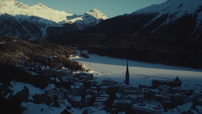 a snowy landscape with mountains in the background