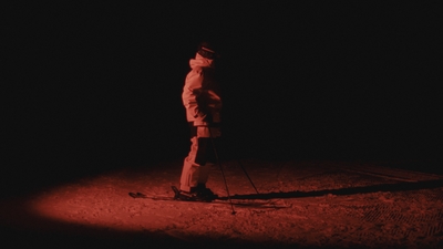 a man standing in the dark on skis