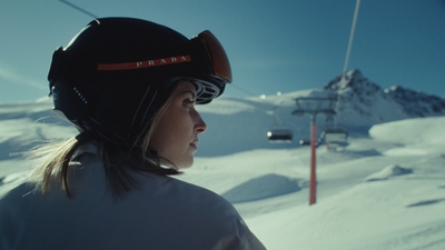 a woman riding a ski lift on top of a snow covered slope