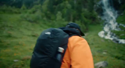 a man with a backpack is looking at a waterfall