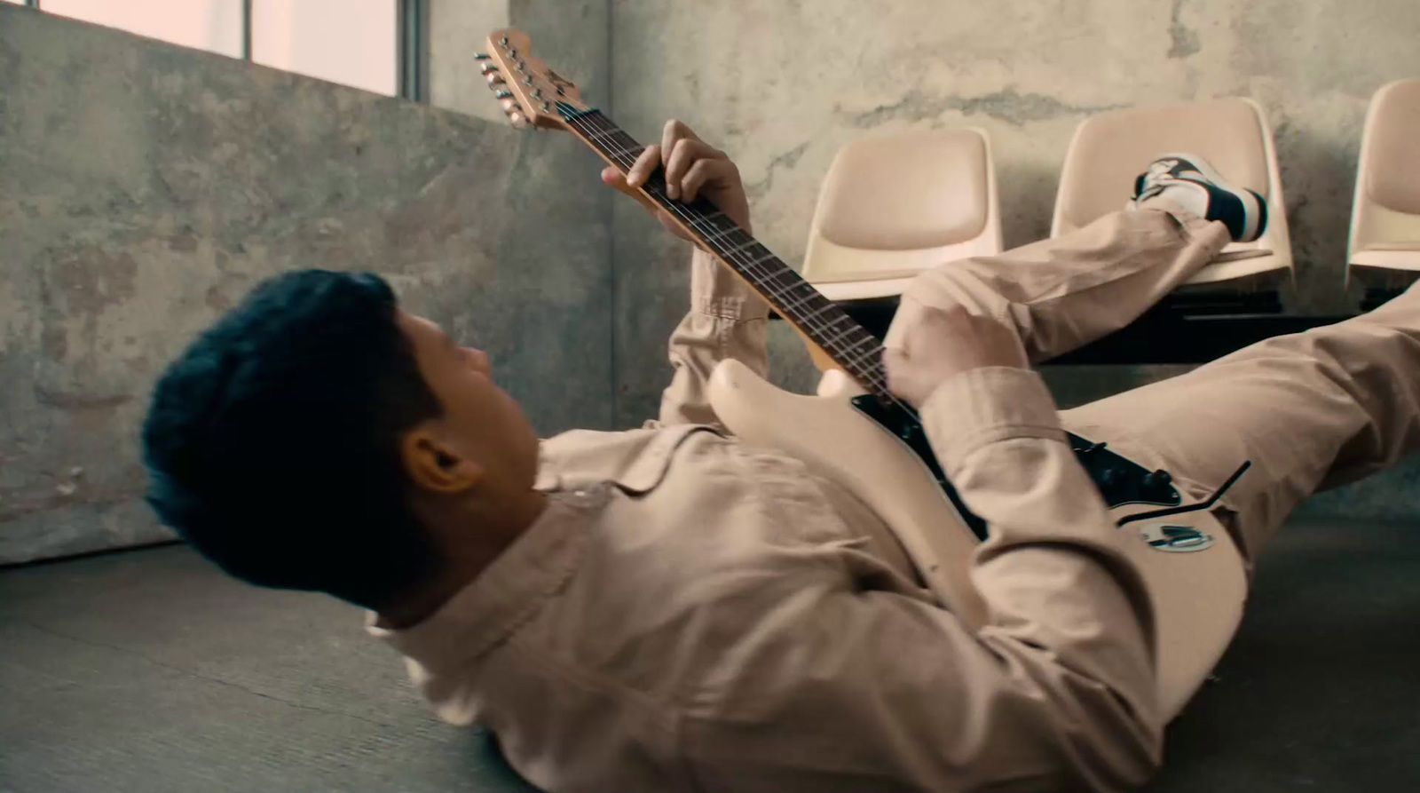 a man laying on the ground with a guitar