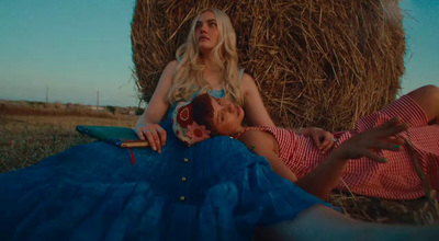 a woman laying on the ground next to a hay bale