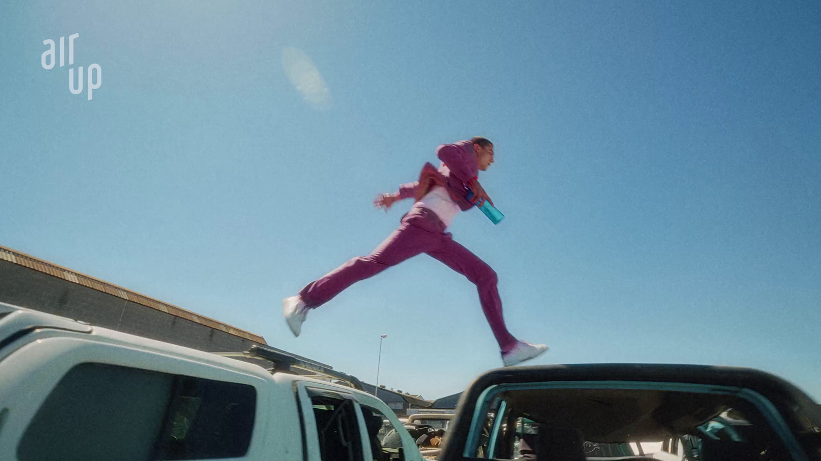 a person jumping in the air in a parking lot