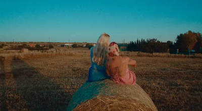 a woman laying on top of a hay bale