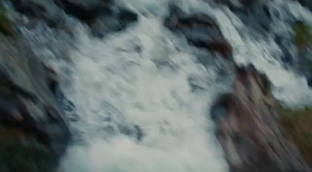 a blurry photo of a waterfall with rocks