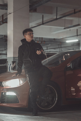 a man standing next to a car in a parking garage