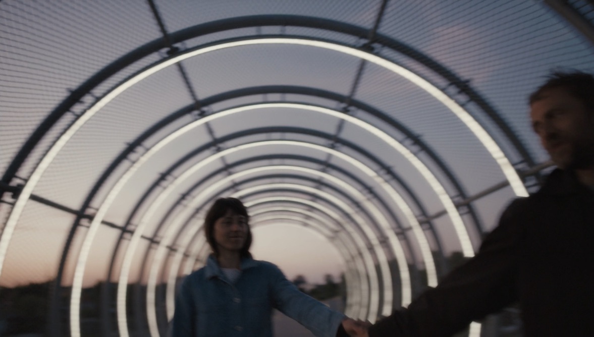 a man and a woman holding hands in a tunnel