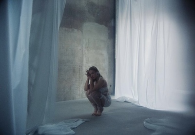 a woman kneeling down in front of a curtain