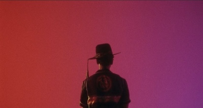 a silhouette of a man with a hat and a gun