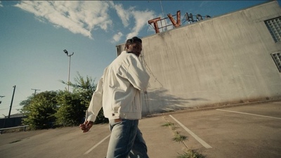 a man is walking in a parking lot