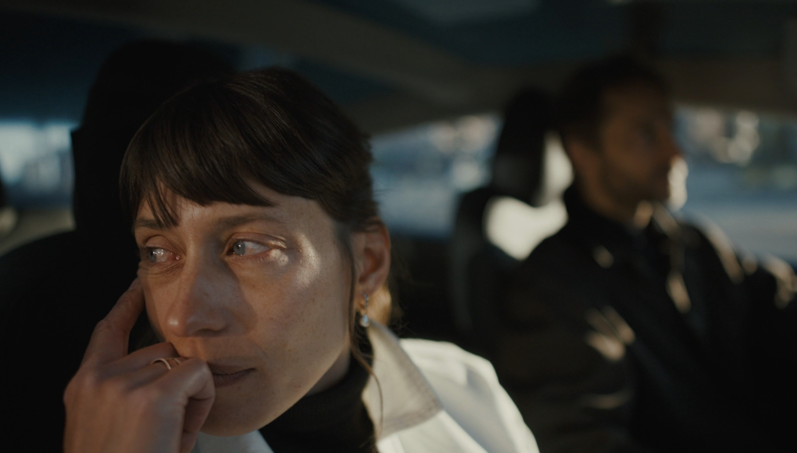 a woman sitting in a car talking on a cell phone