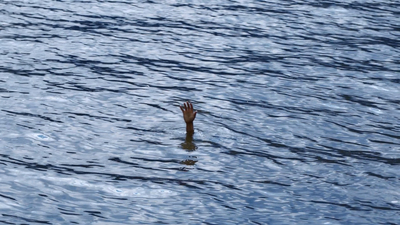 a hand reaching for something in the water