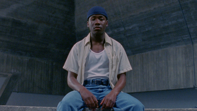 a man sitting on a ledge with a skateboard