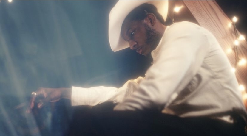 a man in a cowboy hat sitting on a chair