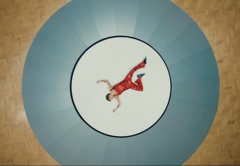 a man in a red suit is floating in a blue circle