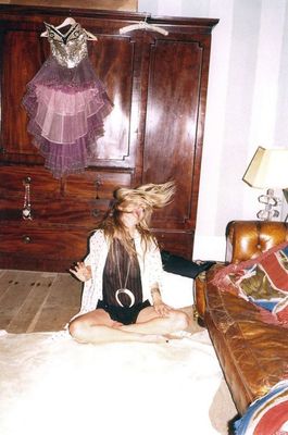 a woman sitting on the floor in front of a dresser