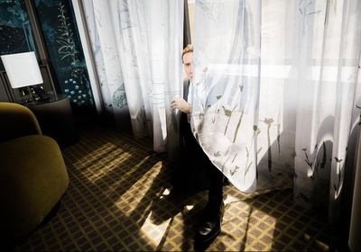 a man standing behind a curtain in a room