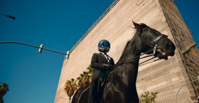 a man in a suit and helmet riding a horse