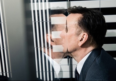 a man in a suit and tie kissing a window