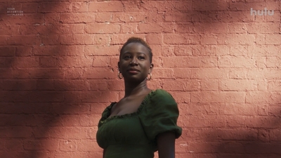 a woman standing in front of a brick wall