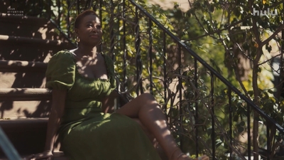 a woman in a green dress sitting on a bench