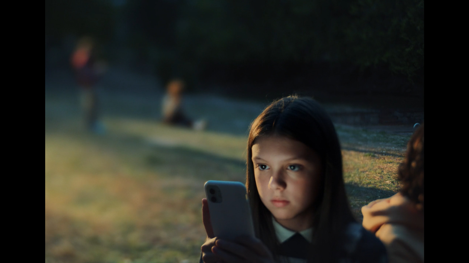 a young girl is looking at her cell phone