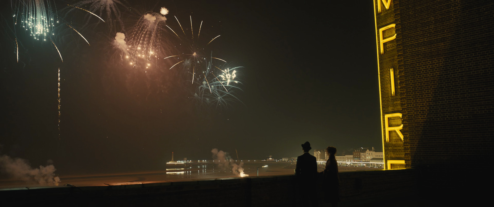 a couple of people standing next to each other watching fireworks