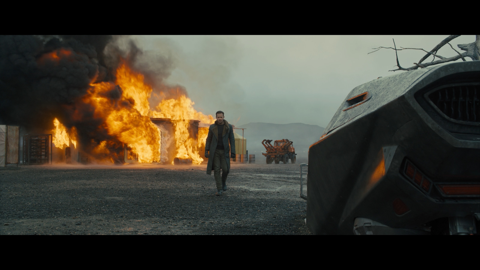 a man standing in front of a burning car