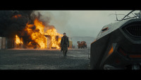 a man standing in front of a burning car