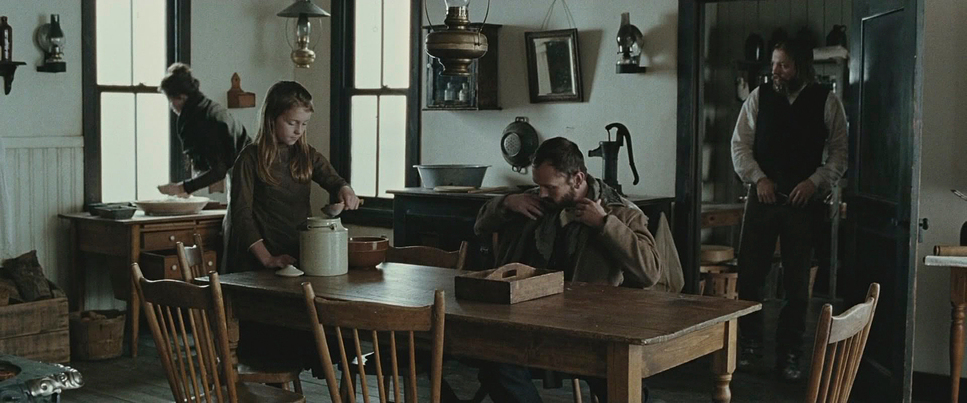 a group of people standing around a wooden table