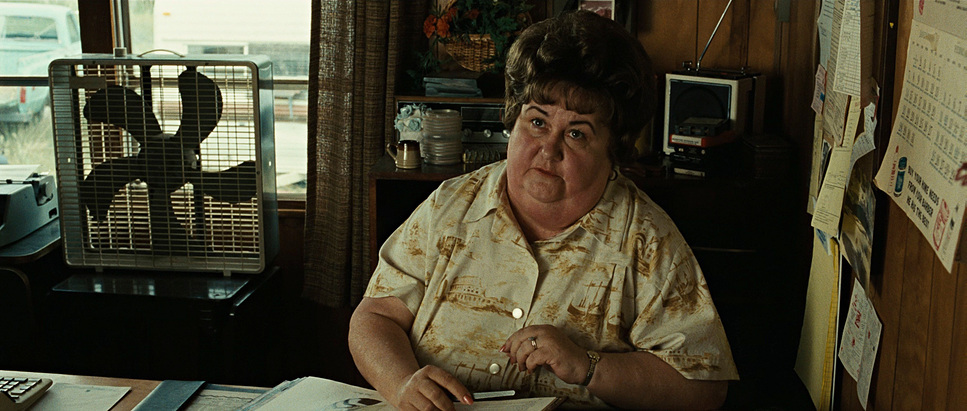 a woman sitting at a desk in front of a computer