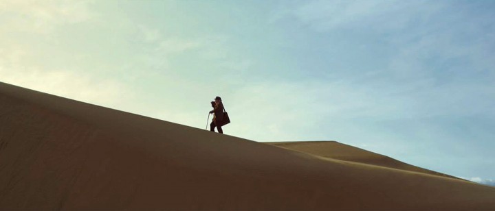 a person standing on top of a sand dune