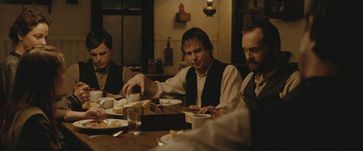 a group of people sitting around a table eating food