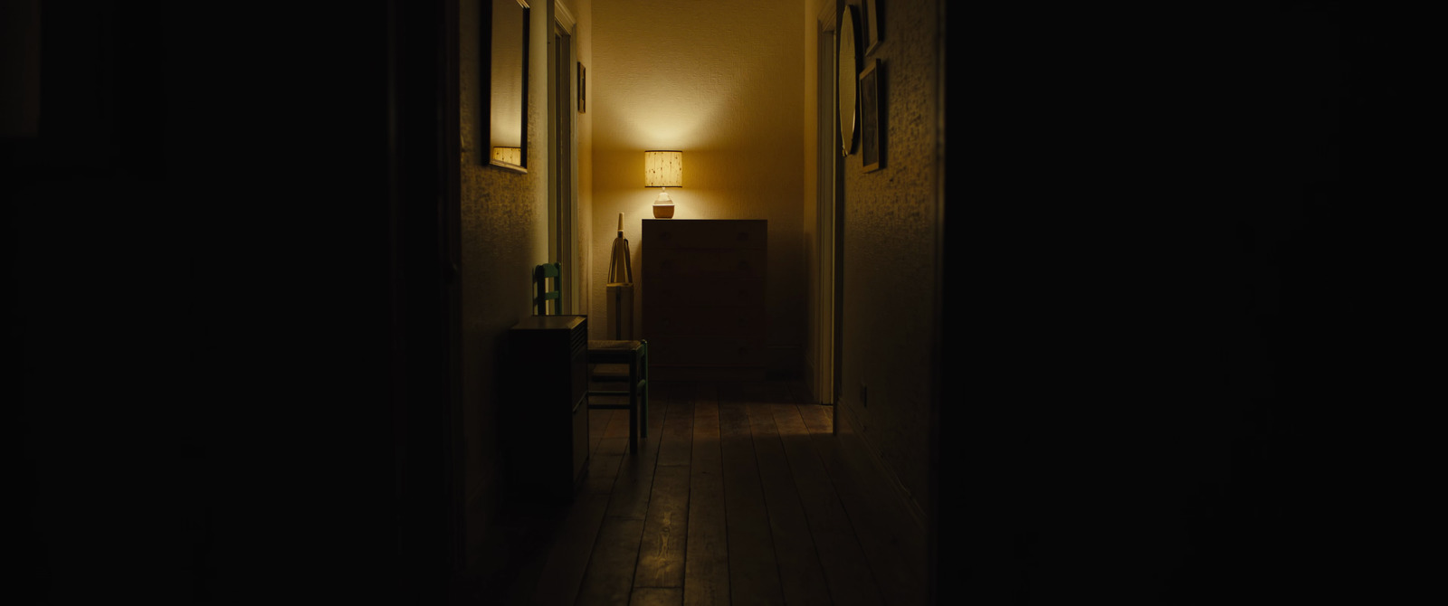 a dimly lit hallway leading to a bedroom