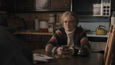 a woman sitting at a table with a tea pot