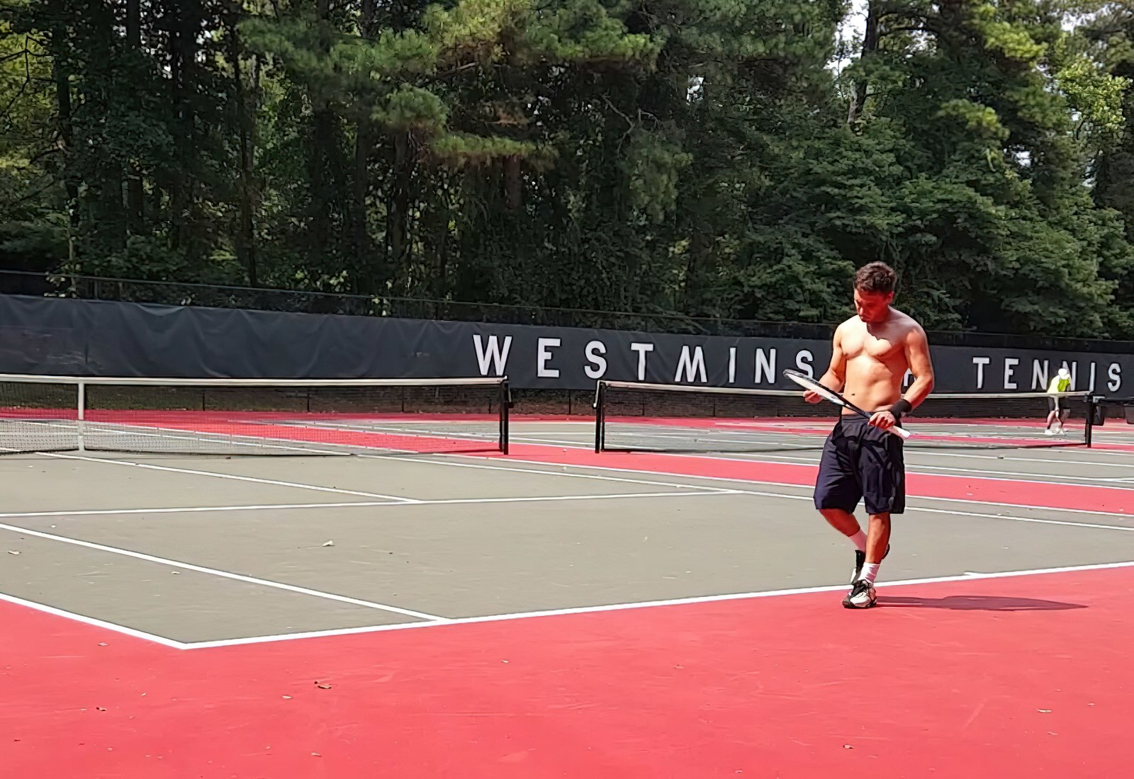 a man standing on a tennis court holding a racquet