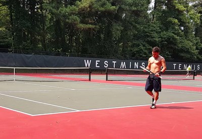 a man standing on a tennis court holding a racquet